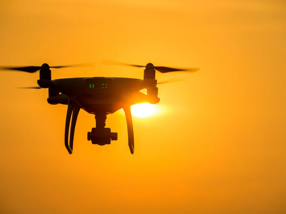 silhouette-drone-with-camera-flying-sunset